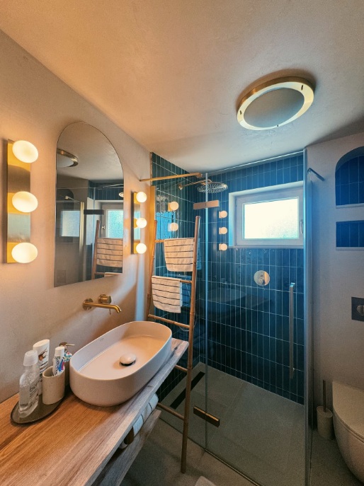 Bathroom with teal tiles and brass details